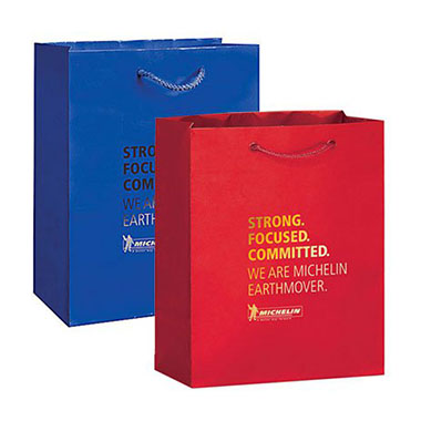 a red and blue laminated paper shopping bags with foil hot stamped text on them