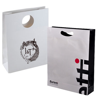 a white and black paper shopping bags with die-cut handle