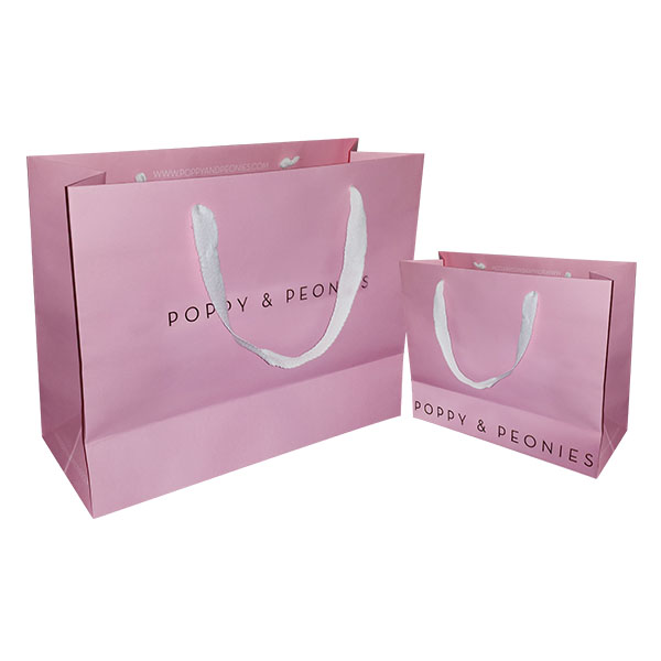 a pair of pink paper shopping bags with white handles