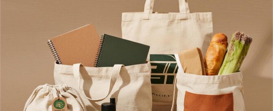 Flat lay of custom canvas tote bags with notebooks, groceries, and accessories—eco-friendly reusable bags for retail branding and promotional use in Canada.